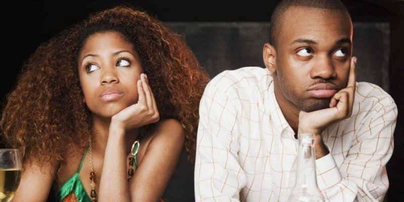 Couple sitting at bar and looking irritated