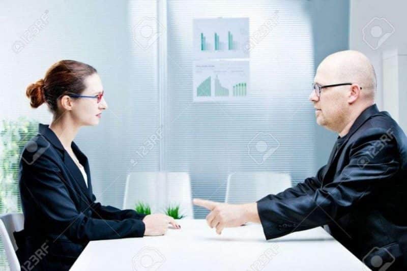 business man and business woman discussing facing each other in a polite discussion